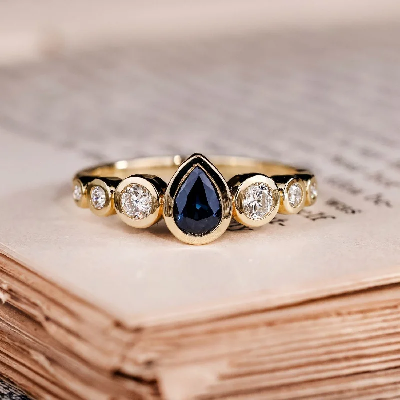 Once-A-Year Jewelry Sale – Grab Your Favorites Now The Lyra - Bezel Set Pear Cut Blue Sapphire Engagement Ring with Diamond Accents Once-A-Year Jewelry Sale – Grab Your Favorites Now The Lyra - Bezel Set Pear Cut Blue Sapphire Engagement Ring with Diamond Accents